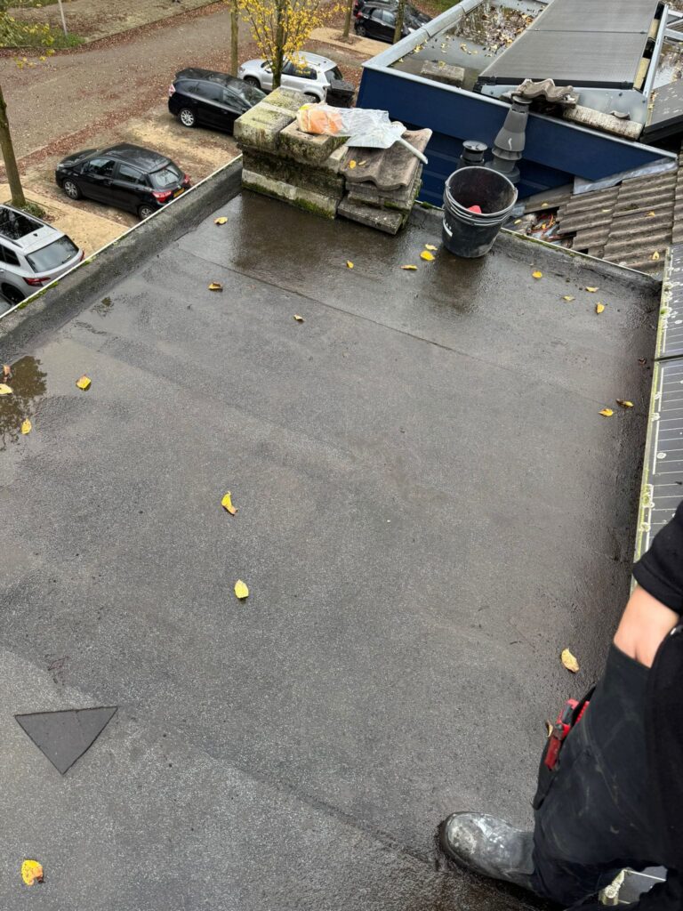 Twee dakkapellen met nieuwe bitumen dakbedekking, zinken dakranden en teruggeplaatste zonnepanelen tijdens een dakrenovatie in Amersfoort.