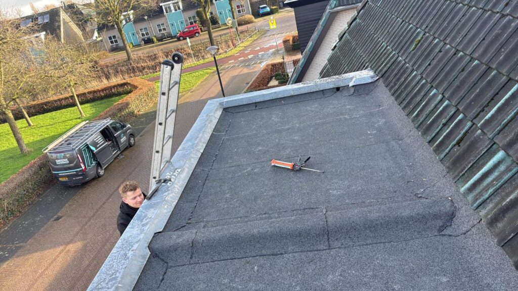 Dakrenovatie in Nijkerk met nieuwe bitumen dakbedekking en hergebruik van zinken dakranden op een dakkapel.